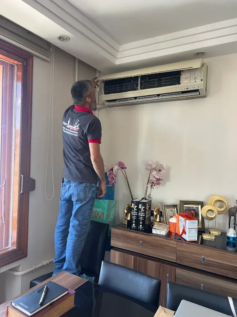 Teknisyen ev ortamında klima iç ünitesini kontrol ediyor