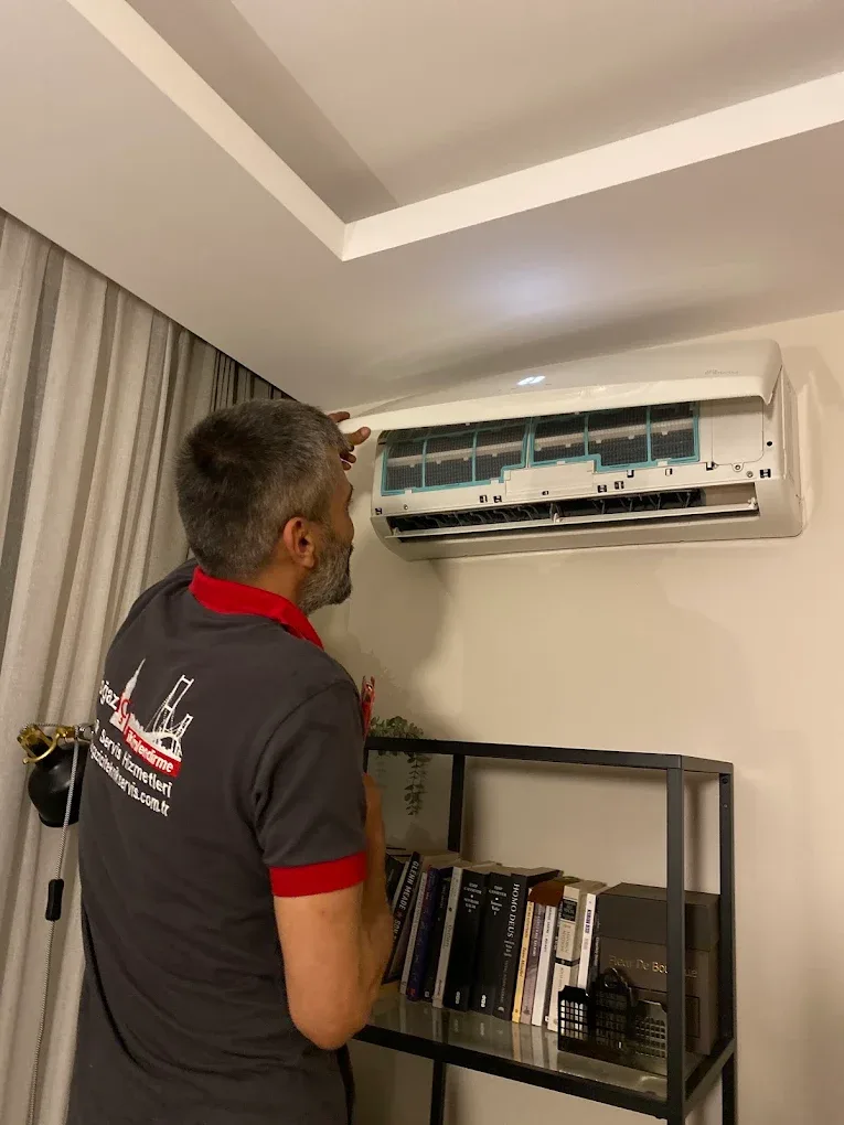 Teknisyen iç ünitenin filtrelerini çıkarılmış hâlde kontrol ediyor